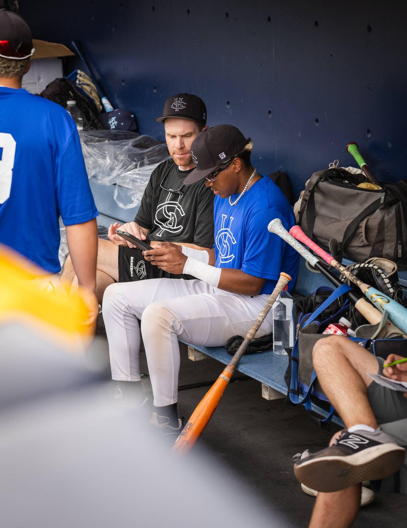 Coach mentoring a player in the dugout